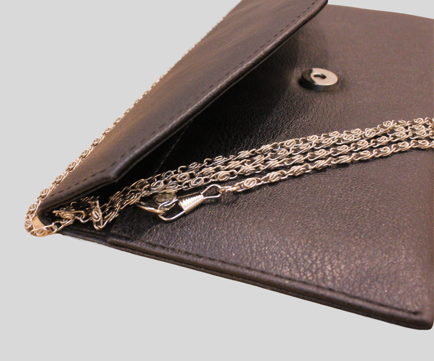 Pochette noire à chaîne au design enveloppe